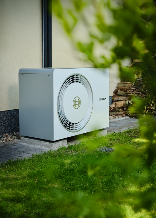 Installierte Bosch Wärmepumpe hinter einem Haus